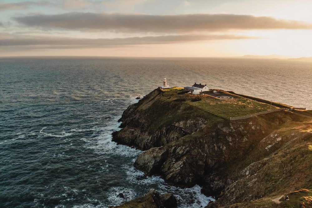 house and lighthouse at the edge of island cliff