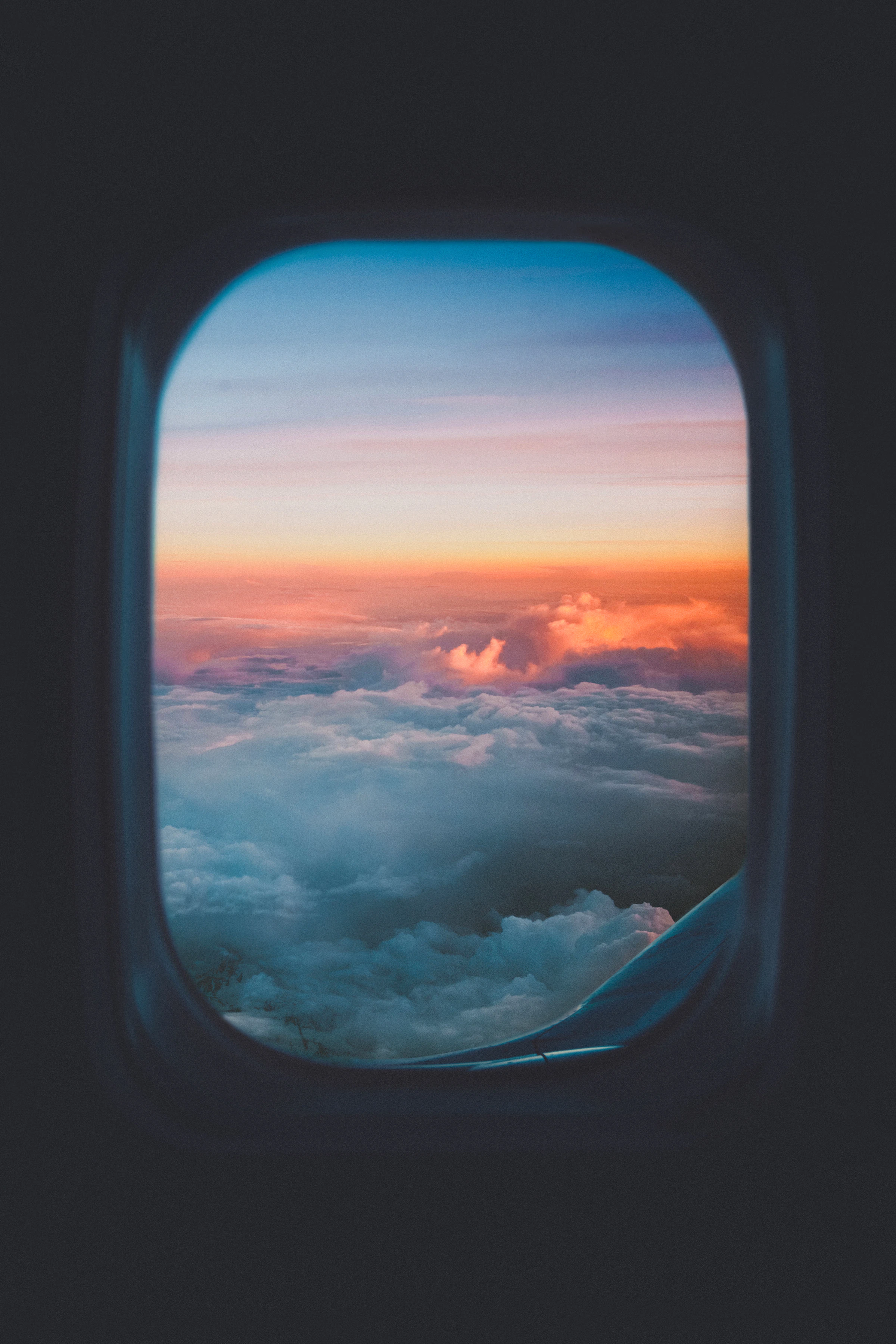 Sea of clouds from a plane window at sunset