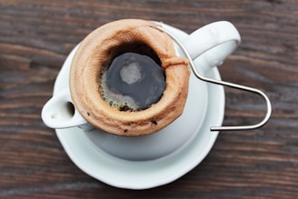 Close-up of a hand holding a coffee cup with coffee grounds visible, ready for a falcı uzay reading.