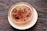 Close-up of a wooden bowl filled with golden jaggery cubes on a rustic kitchen table.