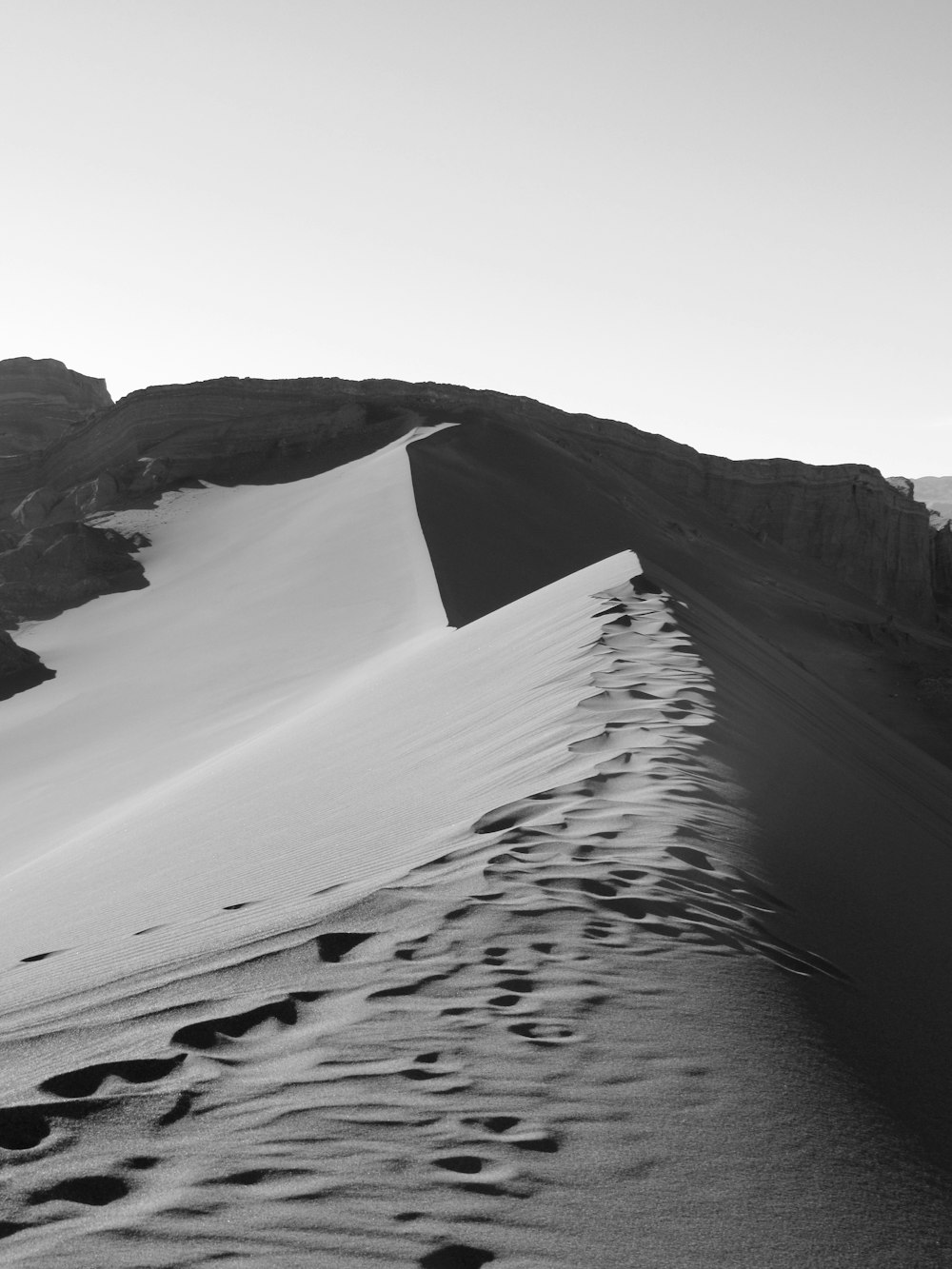 grayscale photography of footprints on desert mountain