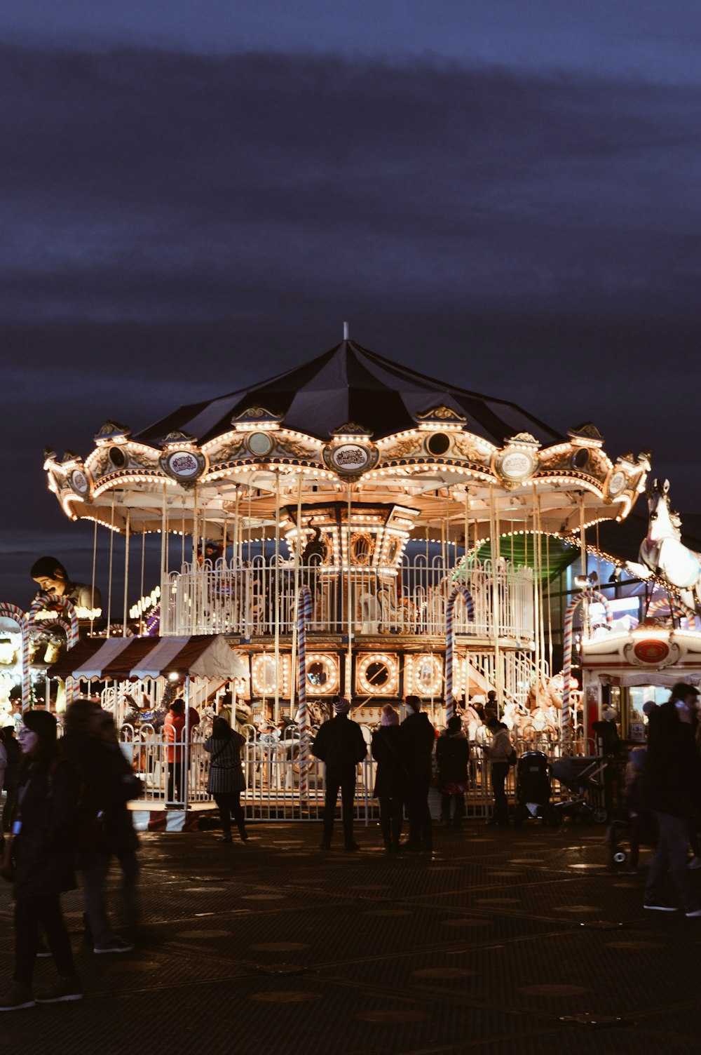 people standing by lighted merry-go-round