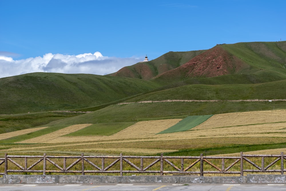 green mountain and field view under blue skies