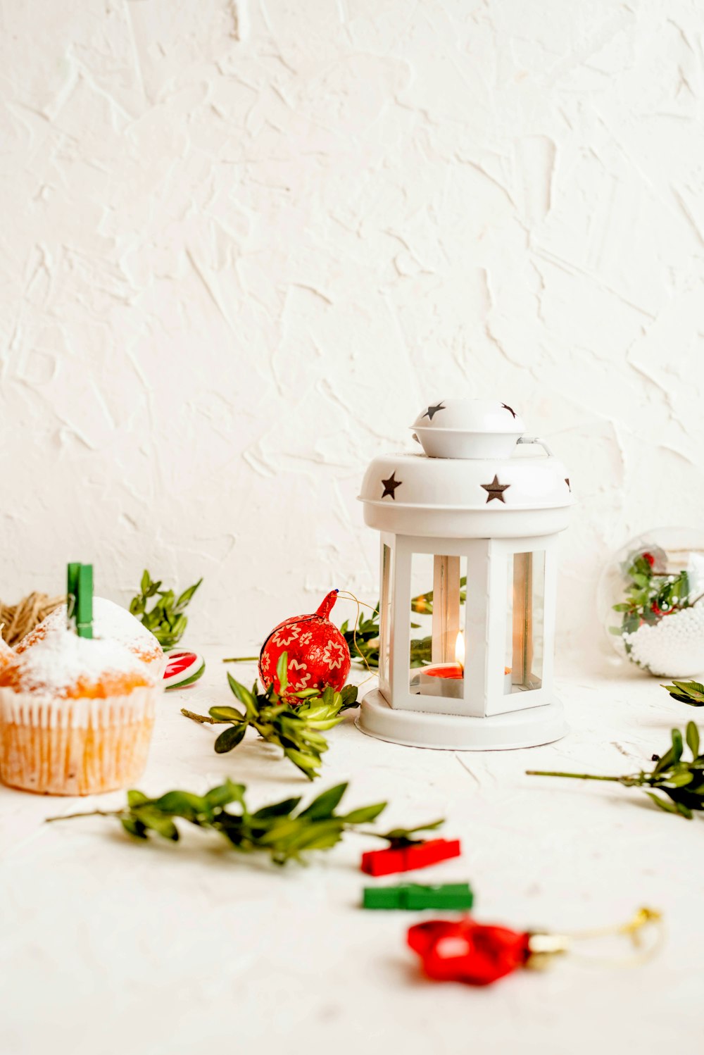 white candle lantern surrounded by leaves