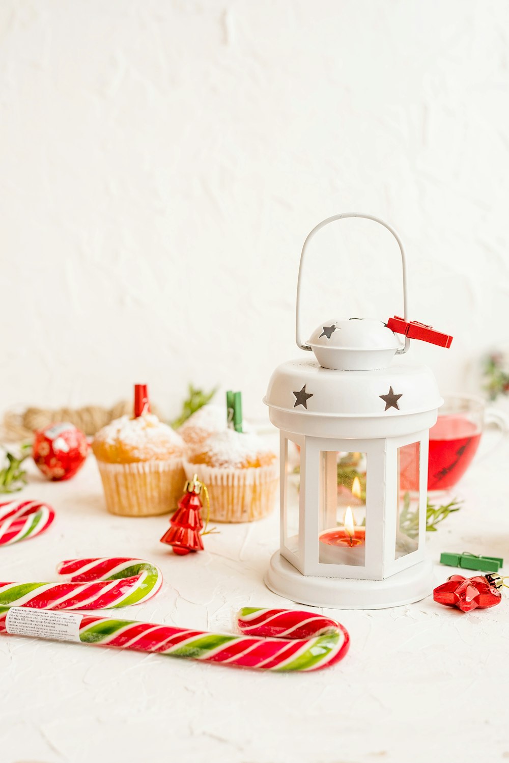 white framed candle holder near candy canes and cupcakes