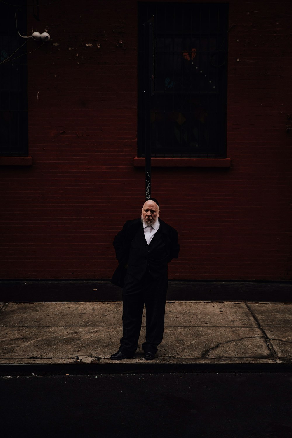 man in black tuxedo standing by the road