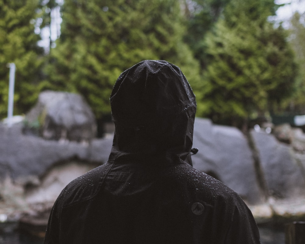 person standing wearing black hooded jacket