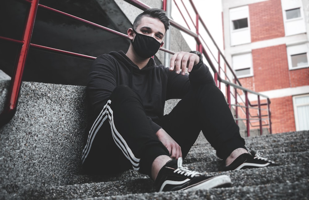 man sitting on stair on focus photography