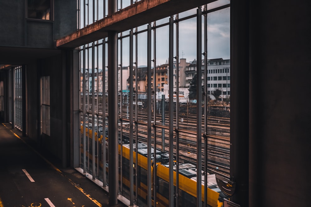 yellow train passing by buildings during daytime