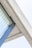 A close-up view of a modern architectural detail, featuring a concrete overhang with a glass window and curtain. The image captures the intersection of the concrete structure and the blue-tinted window, highlighting the texture of the concrete and the smoothness of the glass.