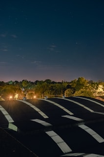 A night shot of a roof shrink wrap project illuminated by work lights, capturing the protective covering in detail.