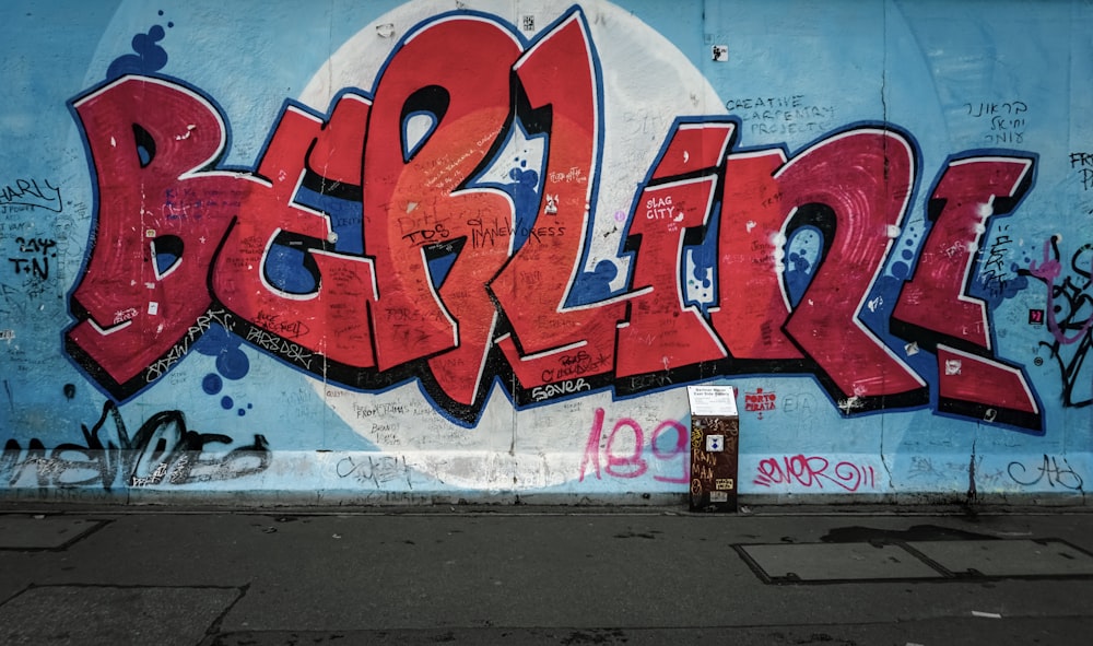 red Berlini word painted on wall with blue background