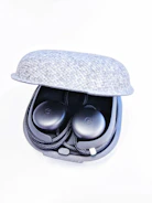 A lineup of sleek wireless earbuds resting on a textured dark gray fabric.