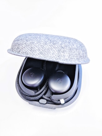 A sleek black and blue wireless earbud set resting on a modern charging case glowing softly.