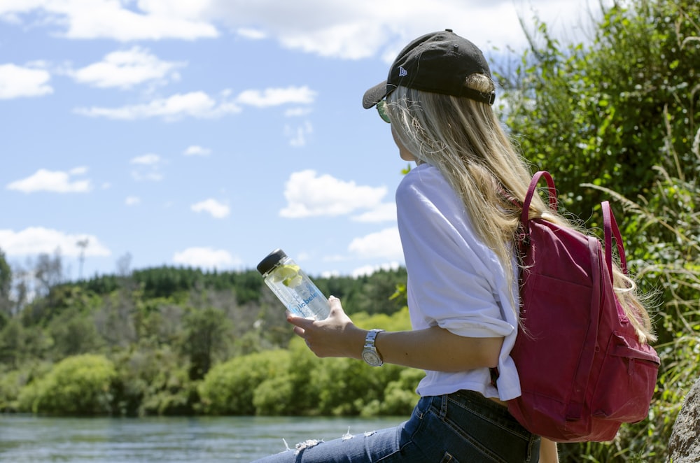 woman in white shirt holding bottle