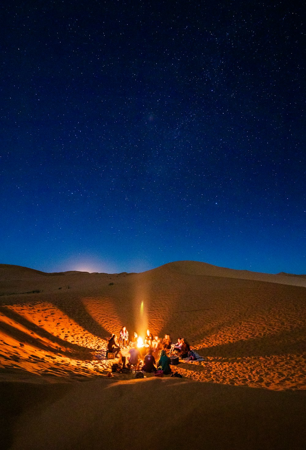 people sitting near bonfire during night time