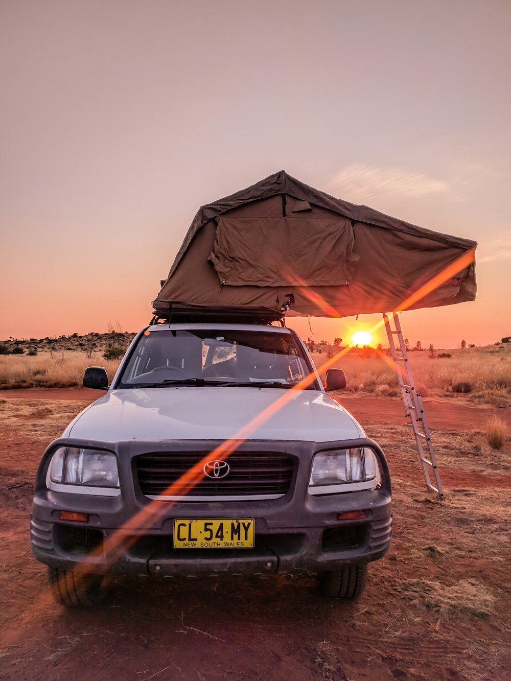 white Toyota car parked under orange sun