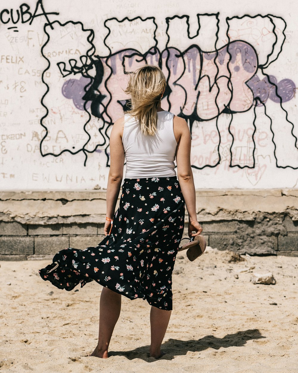 woman wearing white tank top with skirt carrying skirt