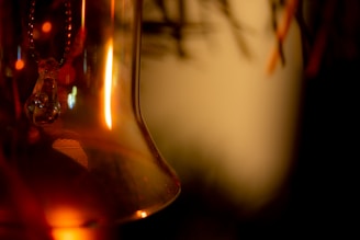 Close-up of a handmade Christmas ornament crafted from recycled materials, glowing softly in warm holiday light.