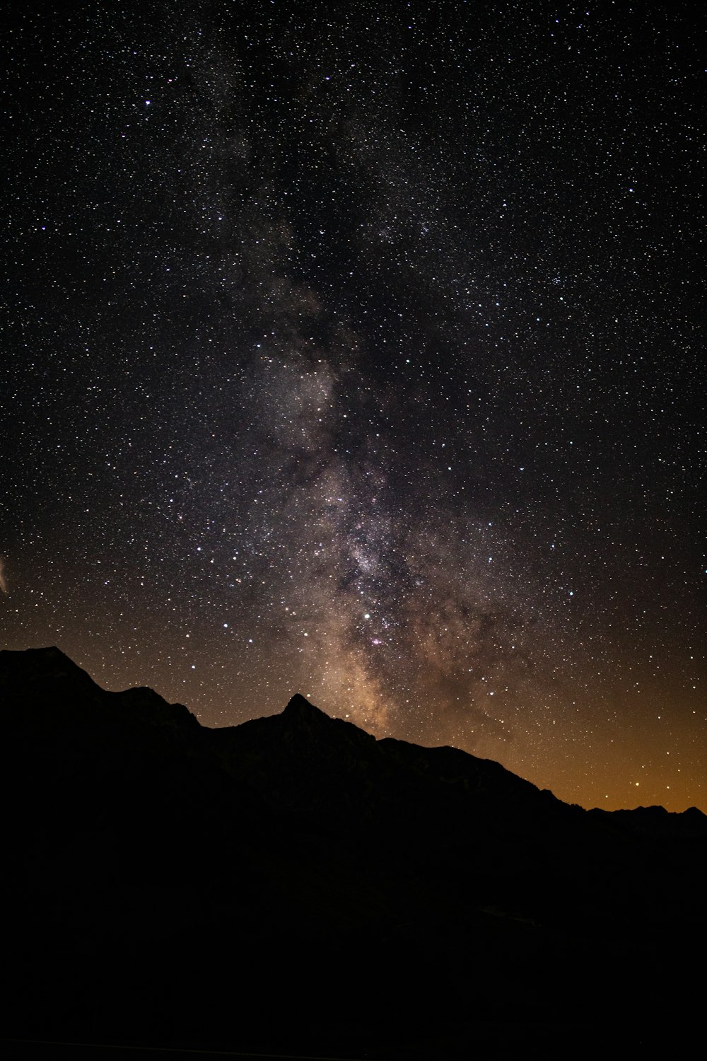 silhouette of mountain under starry sky