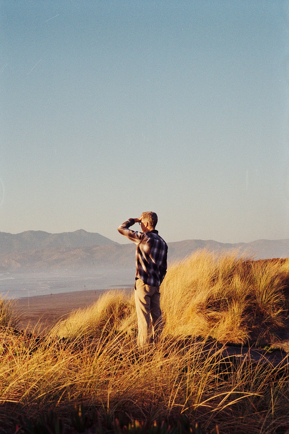 man standing on brown grass during daytime