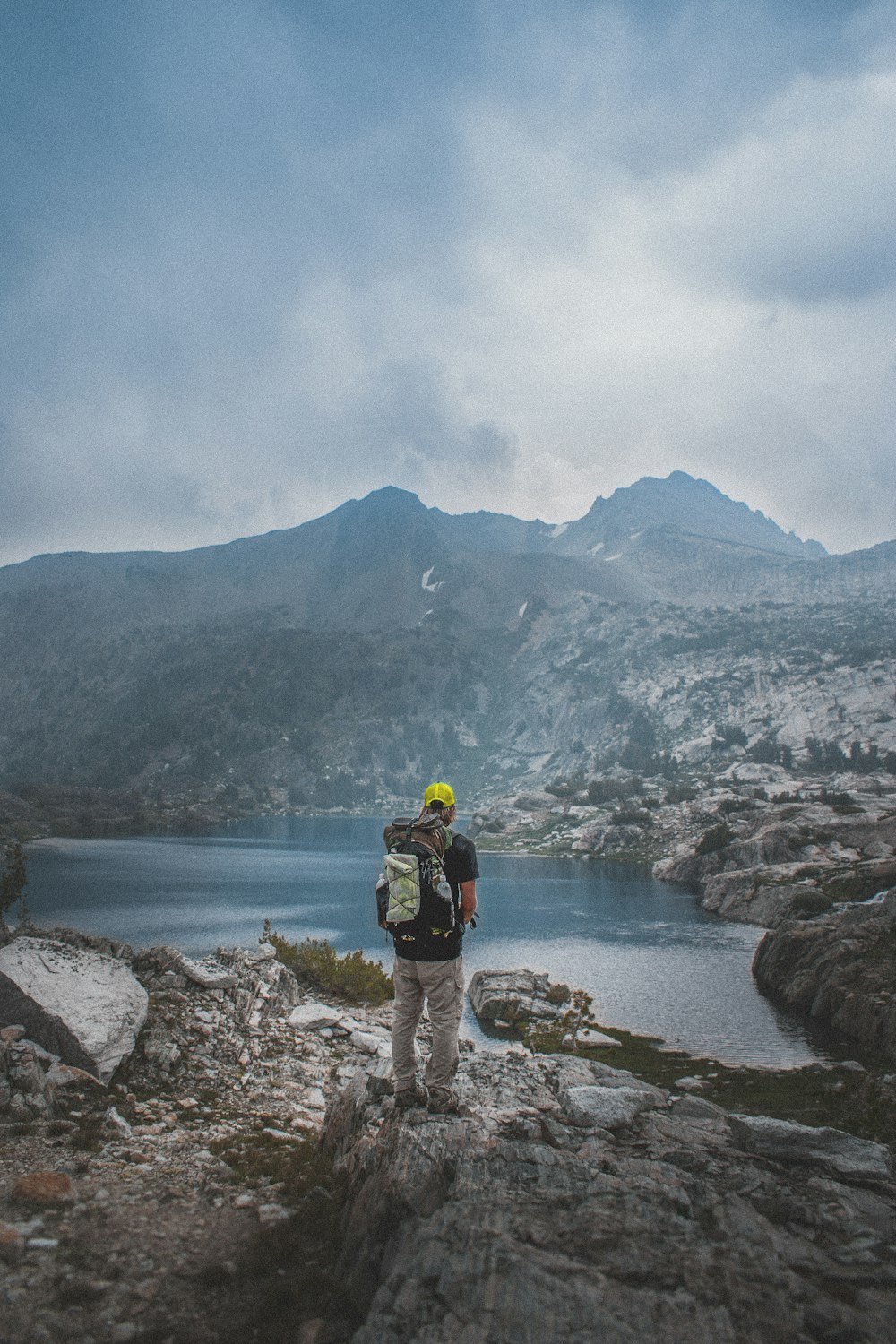 Homem em pé na montanha rochosa cinzenta