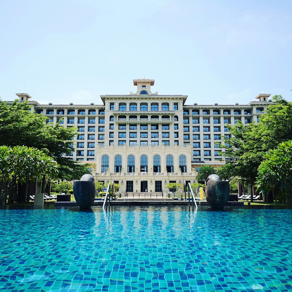 blue swimming pool beside white building