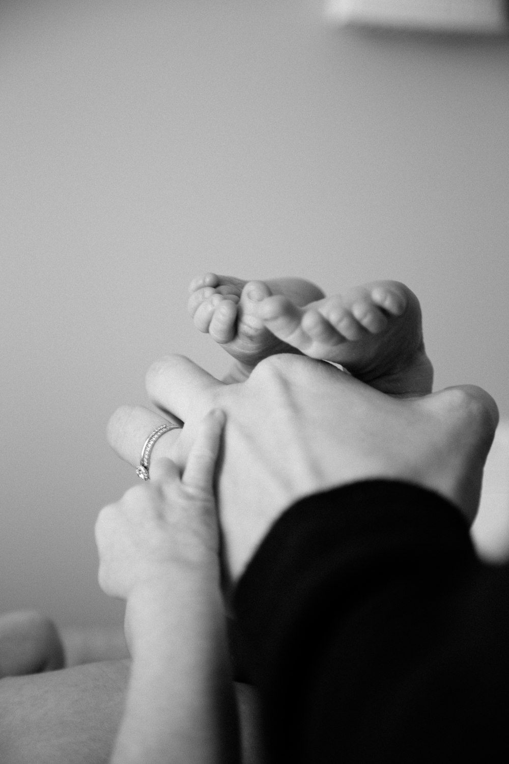 grayscale photography of baby's and person's hands