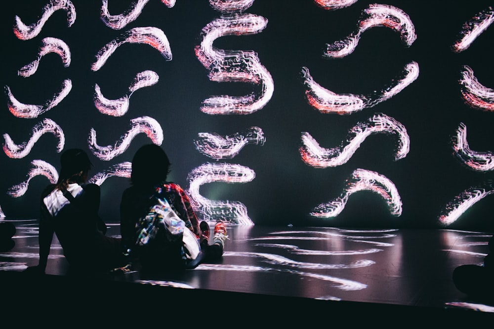 two person sitting on black surface