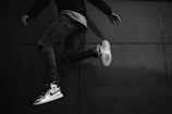 Dynamic shot of someone jumping mid-air wearing bright sneakers against a blue sky.