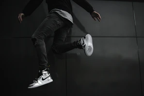 Dynamic shot of someone jumping mid-air wearing bright sneakers against a blue sky.