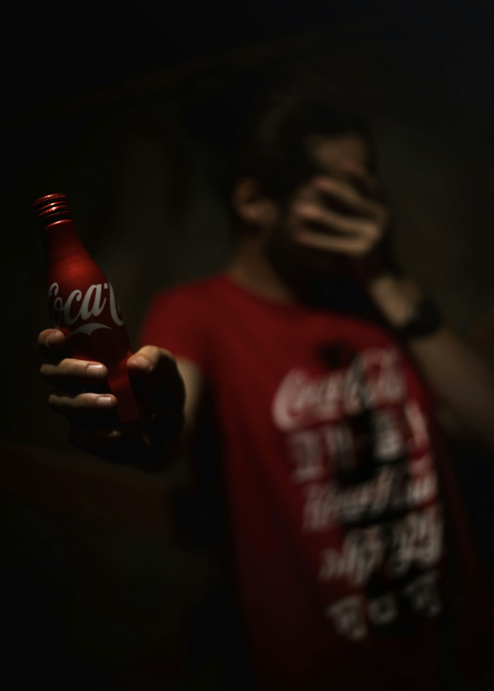 hombre sosteniendo una botella de Coca-Cola