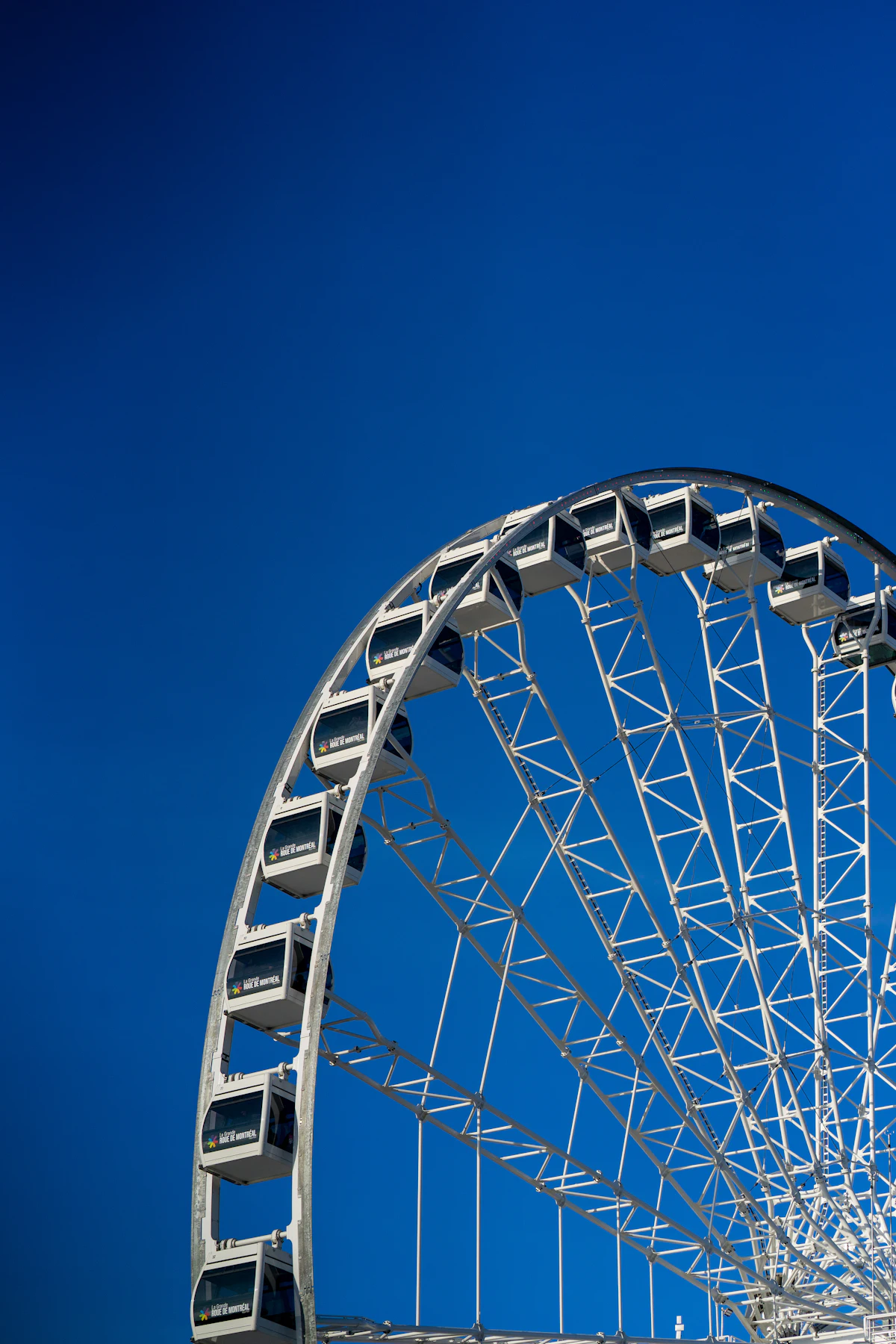 White Ferris wheel at Montreal's Old Port under a blue sky