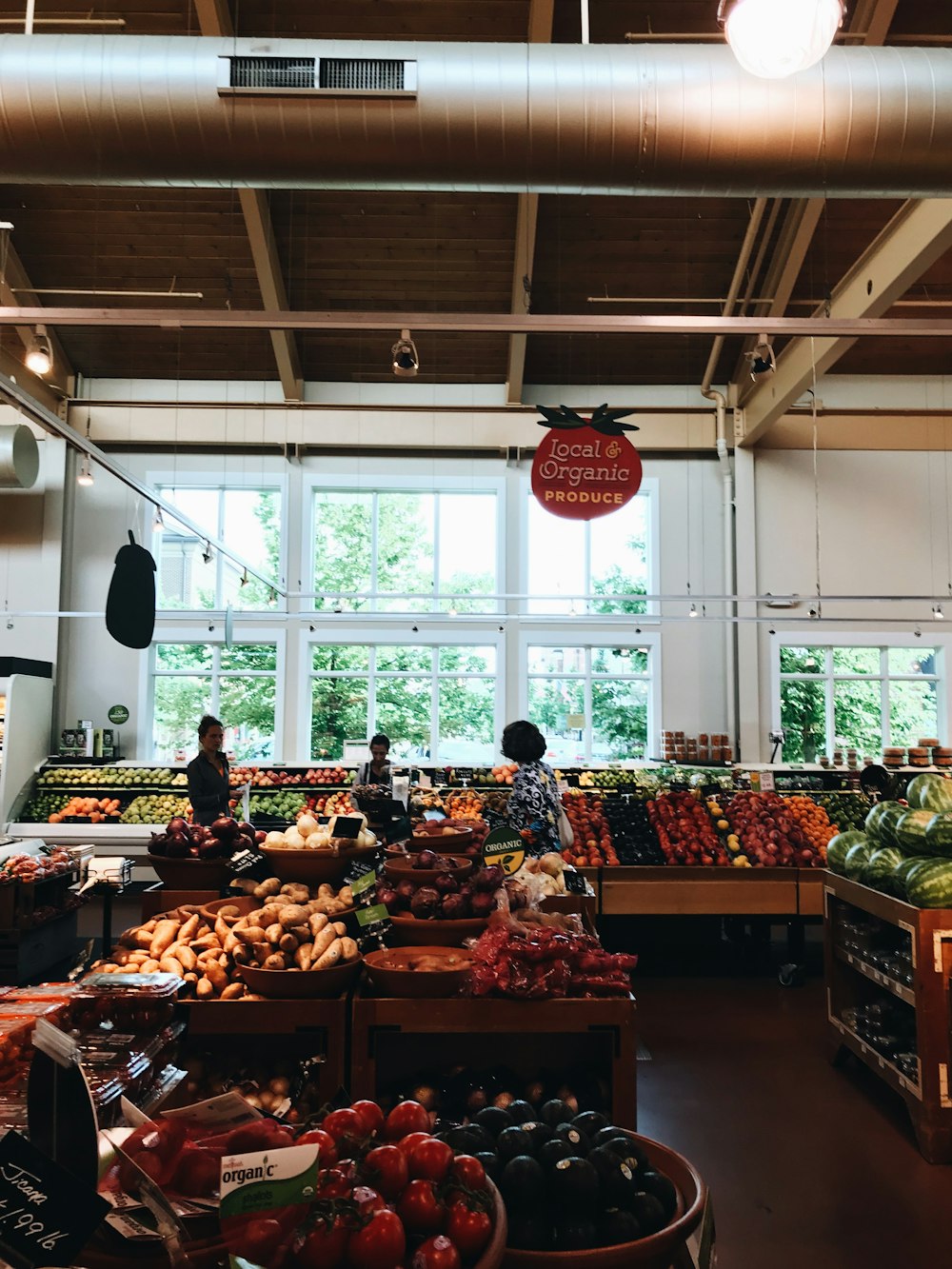 Groupe de personnes à l’intérieur du marché à la section des fruits