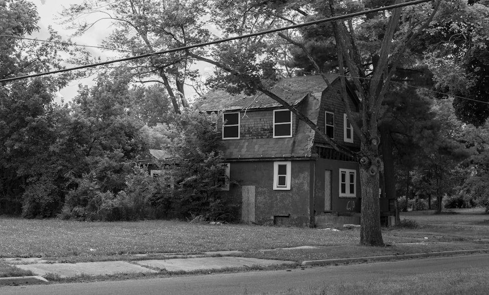 greyscale photo of concrete house surrounded with trees