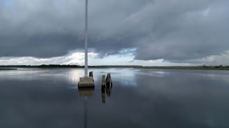 Kallipr water quality monitoring device mounted on a pole above a calm water reservoir.