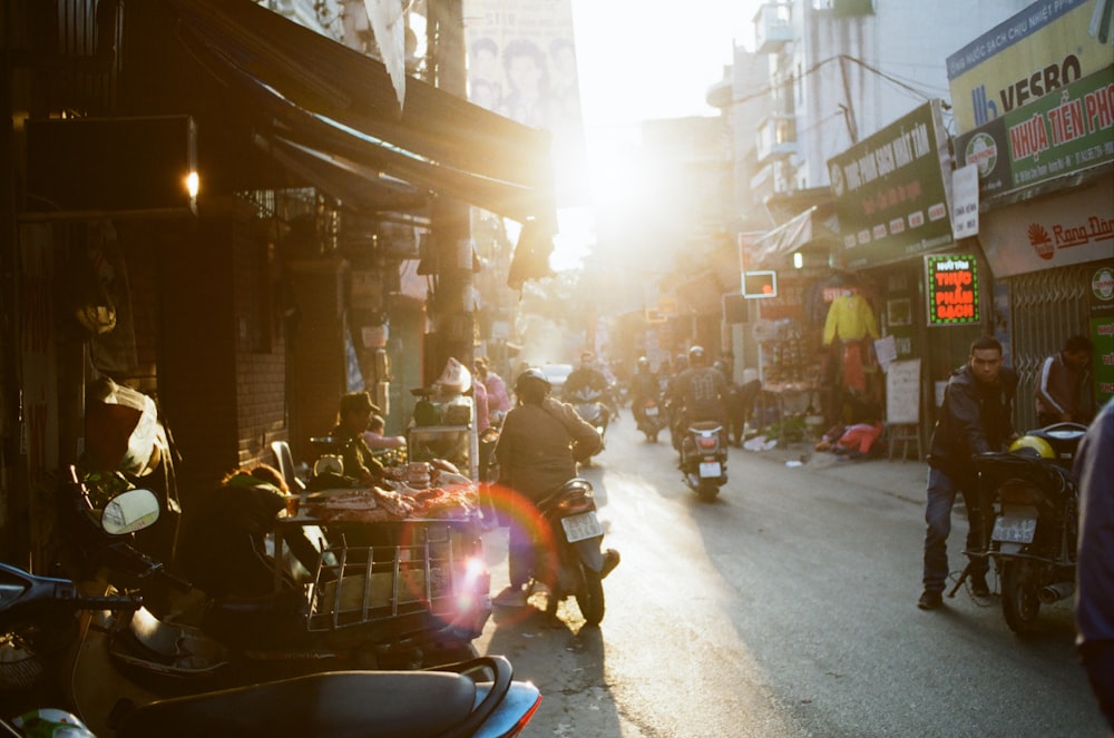 man holding motorcycle on road between buildings