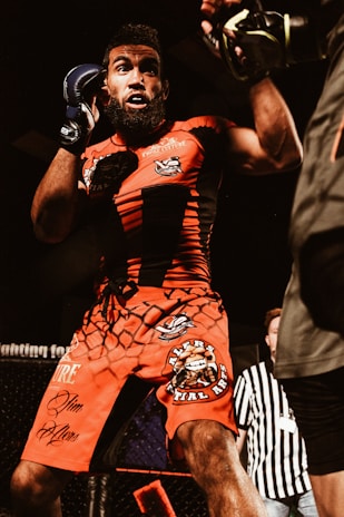 Athlete wearing a sleek Kaiken International MMA rashguard and fight shorts, mid-training in a bright dojo.
