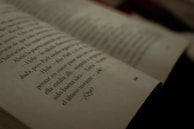 A close-up view of an open book with text written in Spanish. The focus is on a specific page with some words slightly out of focus, creating a cinematic, introspective atmosphere.