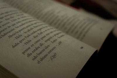A close-up view of an open book with text written in Spanish. The focus is on a specific page with some words slightly out of focus, creating a cinematic, introspective atmosphere.