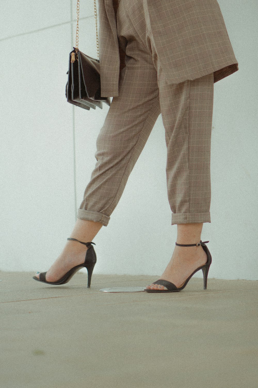 person wearing brown pants and black heels