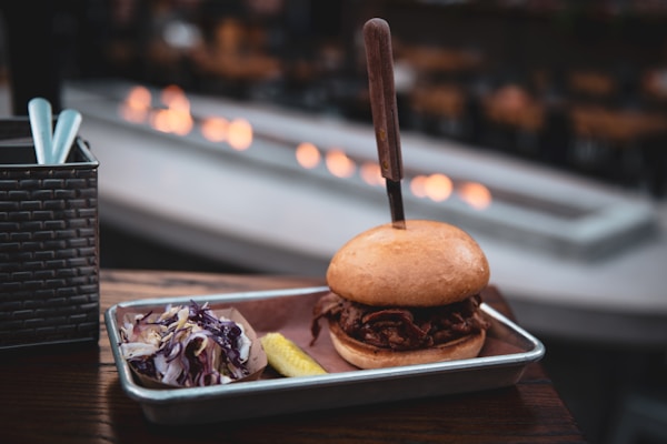 Burger beside coleslaw on tray
