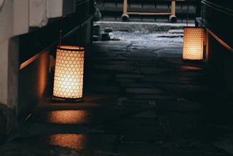 Elegant outdoor lanterns softly illuminating a garden path at dusk.