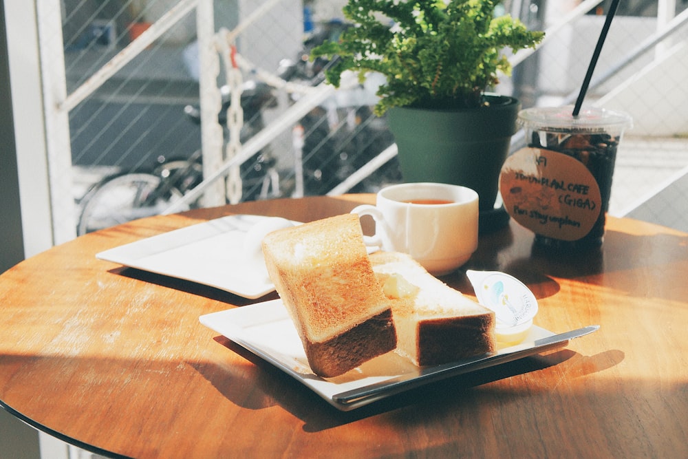 sliced bread on plate beside cup