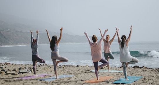 five woman standing on seashore