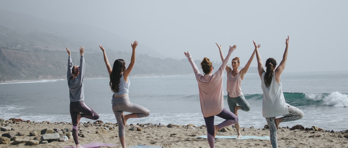 five woman standing on seashore