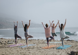 five woman standing on seashore