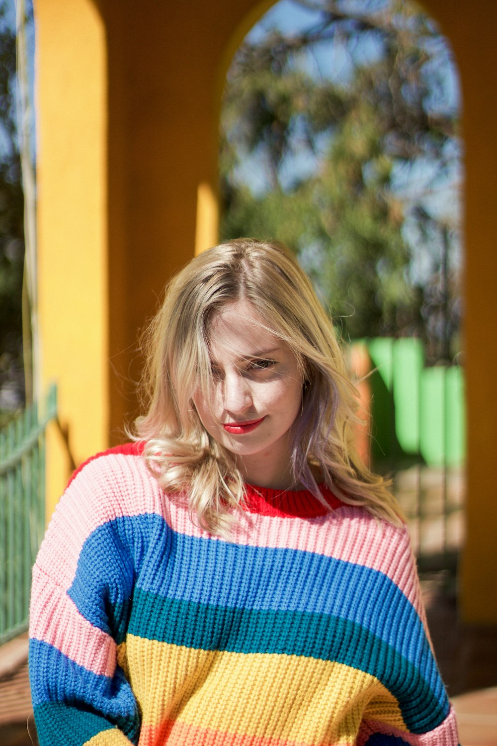 Mujer con suéter de punto a rayas rojas, rosas, azules y amarillas