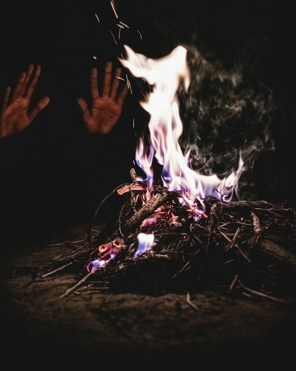 person heating both hands on bornfire