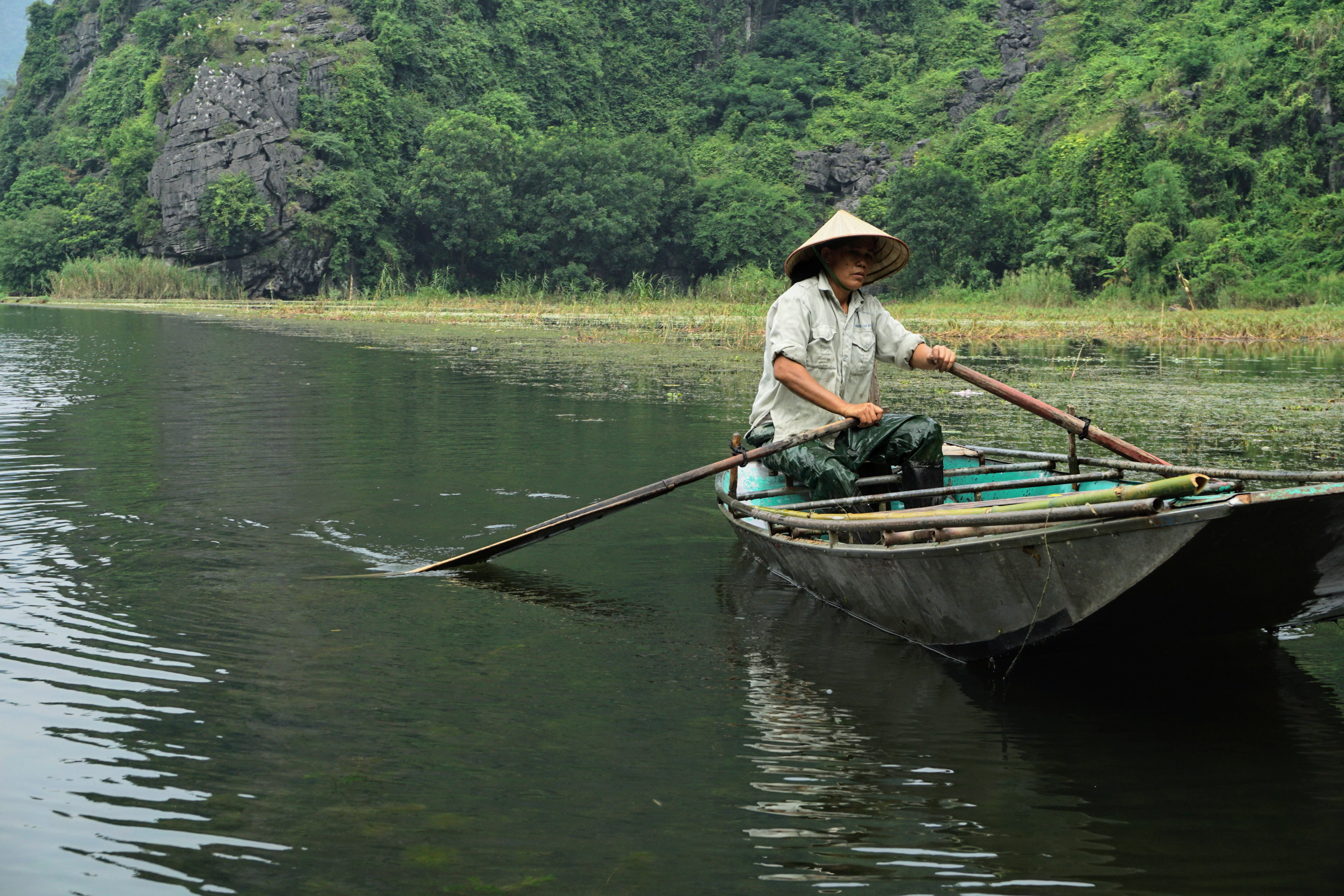 Valtininkas irkluoja upe po kalkakmenio kalvomis Tam Koke, Ninh Binh